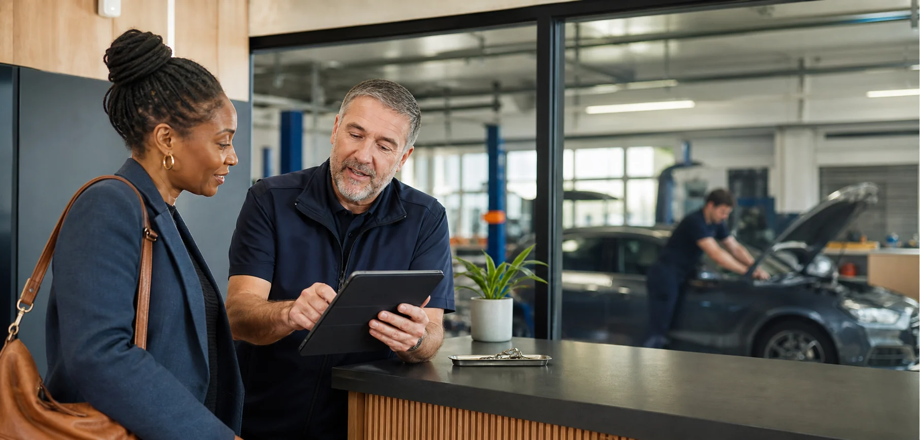 Garage service adviser discussing supported vehicle information with a driver